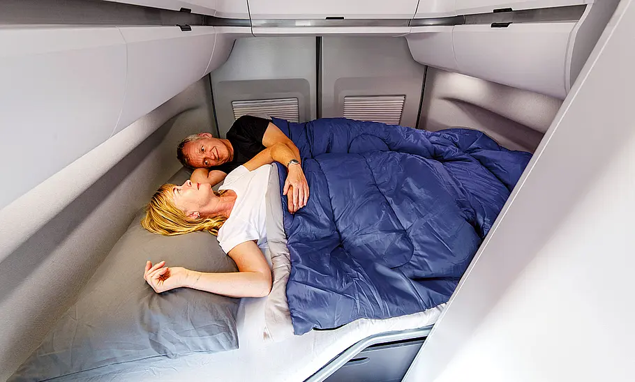 VW Grand California (2018) Ein Paar liegt im Bett im Heck des VW Grand California (2018).