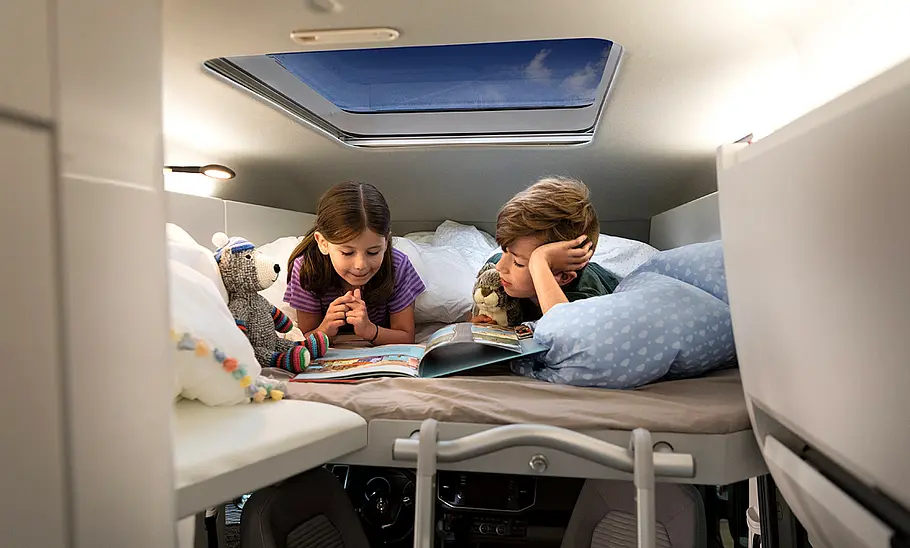 VW Grand California (2018) Zwei Kinder liegen im Hochbett des VW Grand California (2018).