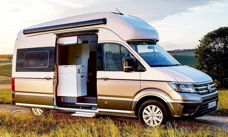 VW Grand California (2018) Der VW Grand California (2018) stehend von schräg vorne fotografiert, mit offener Schiebetür.
