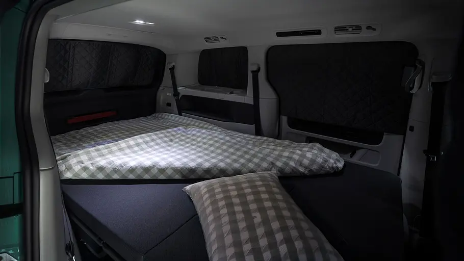 VW ID. Buzz mit Gute-Nacht-Paket Der Innenraum des VW ID. Buzz mit Gute-Nacht-Paket bei Nacht mit Verdunkelungen an den Scheiben.