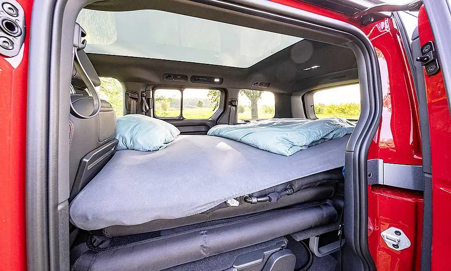Das Afublasbett des VW ID. Buzz mit Stuff Bubble (2025) durch die geöffnete Seitentür fotografiert.