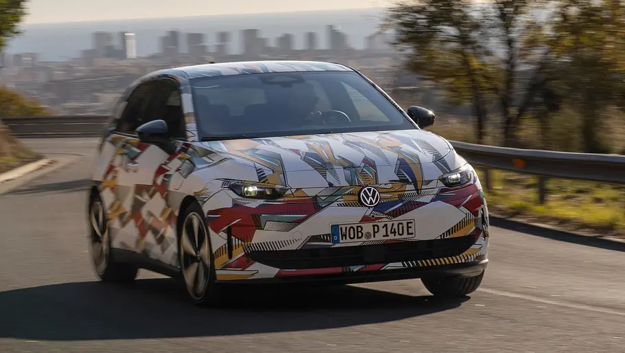 VW ID. Polo (2026) Der VW ID.Polo fährt als getarnter Prototypen über eine Landstraße, von vorne rechts fotografiert.