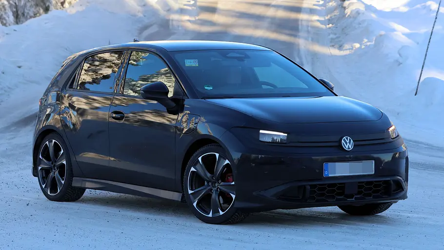 Der VW ID. Polo GTI fährt als Erlkönig auf einer verschneiten Straße, von vorne rechts fotografiert.