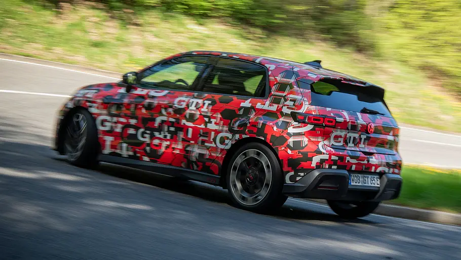 Der VW ID. Polo GTI auf einer Landstraße fahrend von schräg hinten fotografiert.