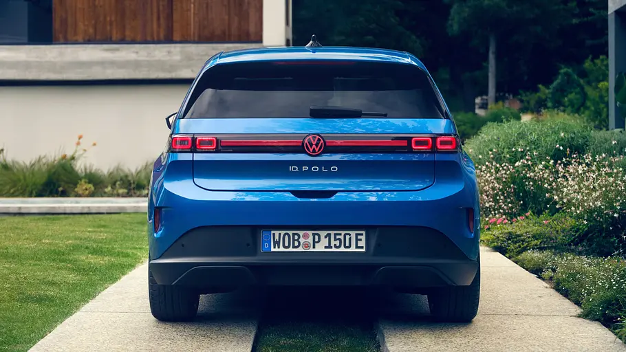 Der VW ID.Polo steht vor einem Haus, von hinten fotografiert.