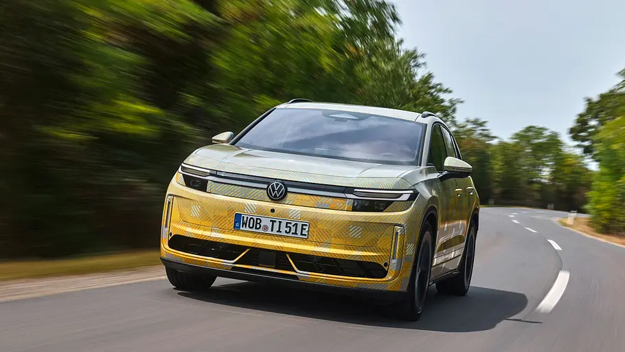 Getarnter Prototyp des VW ID.Tiguan mit gold-blauer Tarnfolie, fahrend von schräg vorn