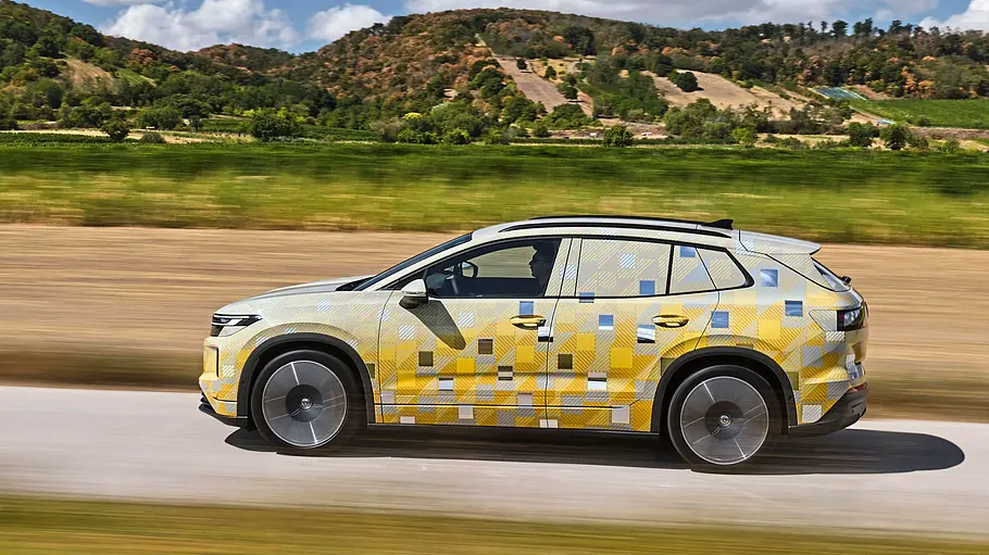 Getarnter Prototyp des VW ID.Tiguan mit gold-blauer Tarnfolie, fahrend von der Seite