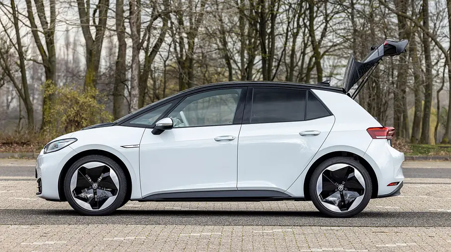 VW ID.3 Der VW ID.3 steht mit geöffneter Heckklappe auf einem Parkplatz, von links fotografiert.