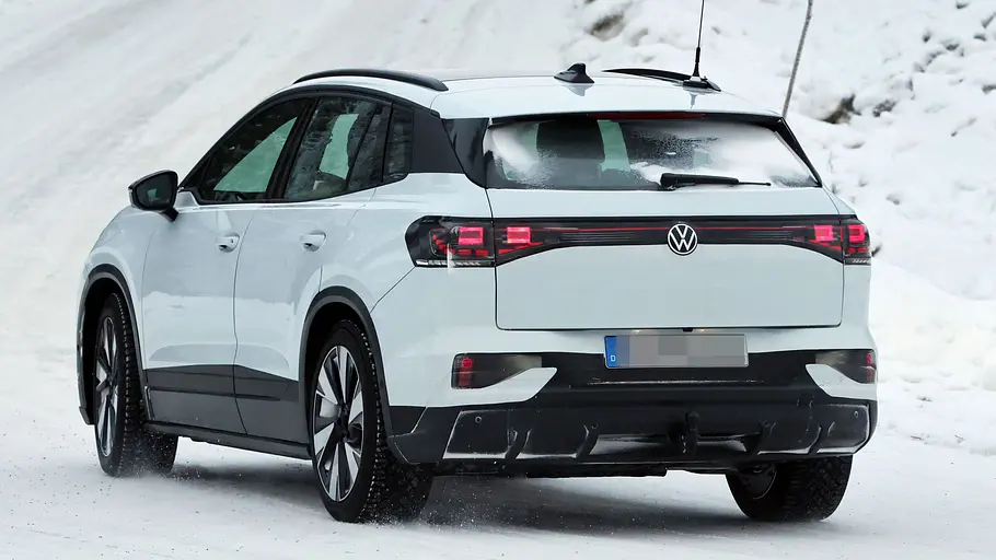 VW ID.4/ID. Tiguan Der VW ID.4 fährt als Erlkönig durch den Schnee, fotografiert von hinten.