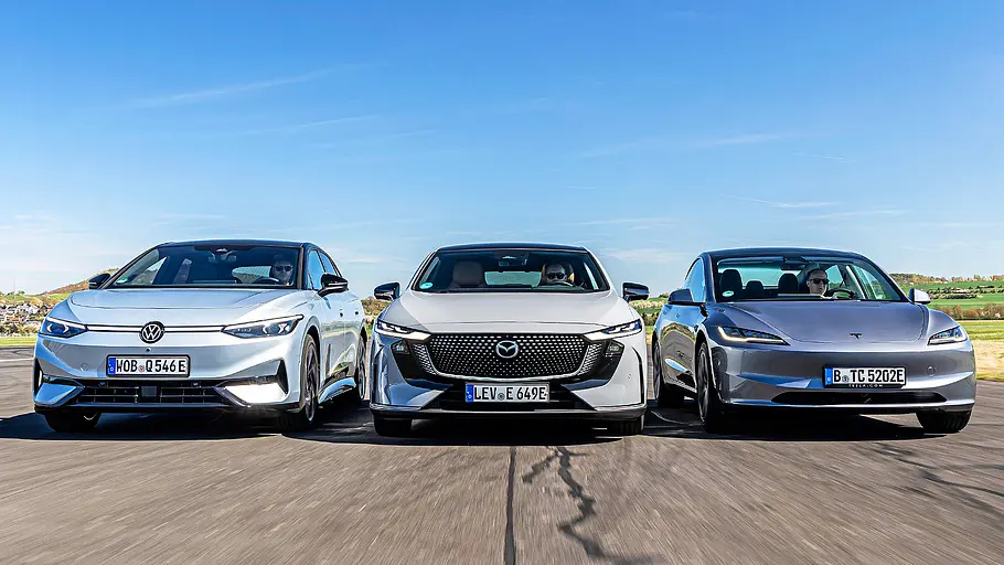 Blick von vorne auf die drei fahrenden Elektro-Limousinen VW ID.7, Mazda6e und Tesla Model 3.