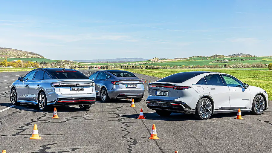 Blick von schräg hinten auf die drei Elektro-Limousinen VW ID.7, Tesla Model 3 und Mazda6e.