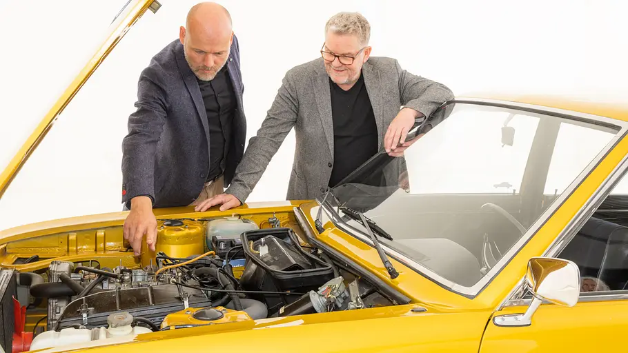Stefan Wallburg und Andreas Mindt stehend am Moto des VW K70.