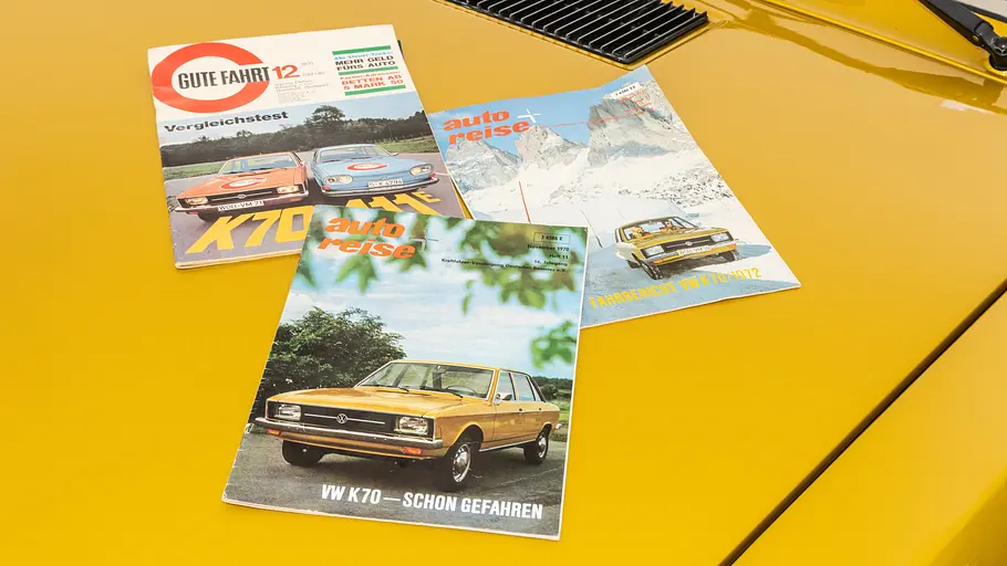 Prospekte des VW K70 liegend auf der Motorhaube.