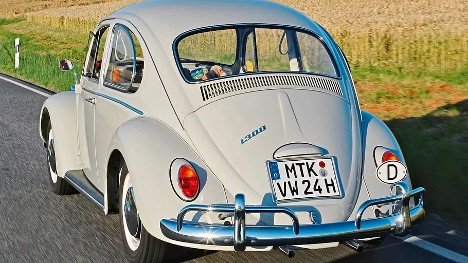 Der VW Käfer fahrend von hinten.