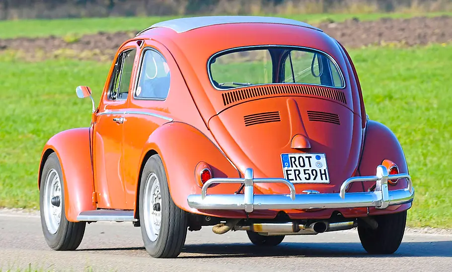 Der VW Käfer mit Porsche 356 Super 90 Motor fahrend von schräg hinten fotografiert.