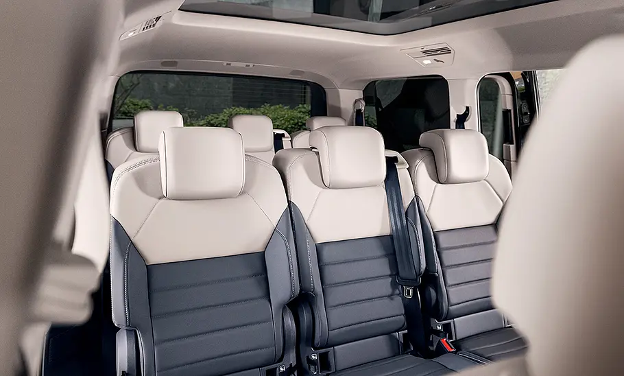 Bild zeigt den Innenraum des achtsitzigen VW Multivan (2021) mit Blick auf die zweite und dritte Sitzreihe.