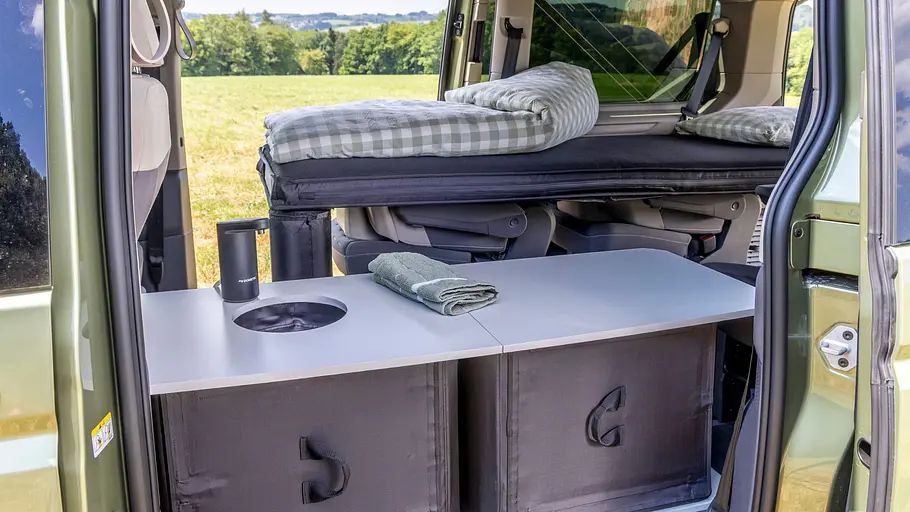 VW-Neuheiten auf dem Caravan Salon 2026 Blick durch die geöffnete linke Schiebetüre in den Innenraum des VW California Beach. Die Heckküche steht im Schiebetürbereich.