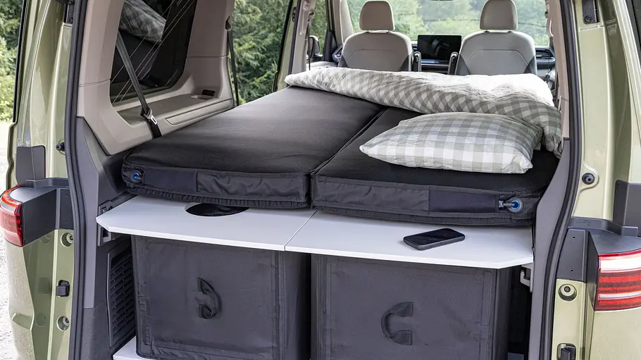 VW-Neuheiten auf dem Caravan Salon 2026 Blick durch die geöffnete Heckklappe in den Innenraum des VW California Beach mit Stuff Bubble-Zubehör im Küchenumbau.