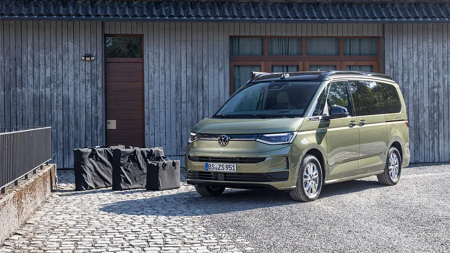 VW-Neuheiten auf dem Caravan Salon 2026 Das zusammengepackte Zubehör-Set von Stuff Bubble neben dem statischen VW California Beach von schräg vorne links.