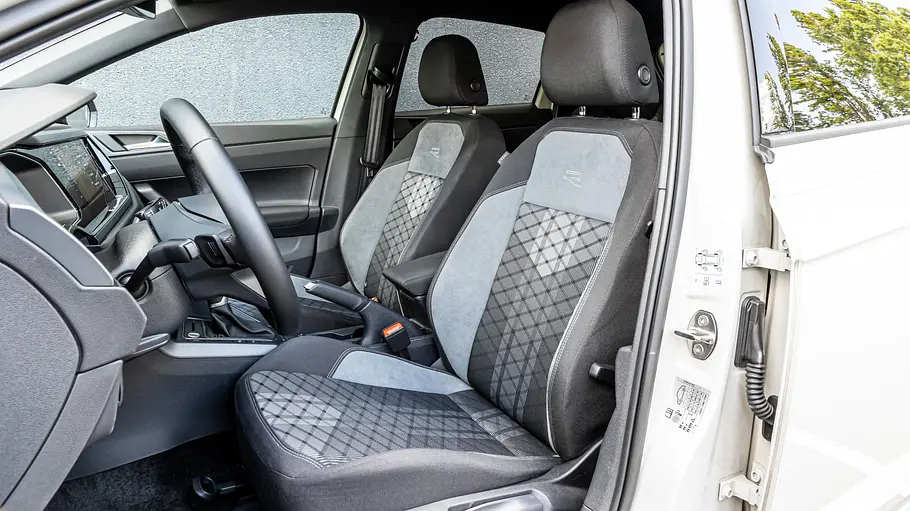 Blick durch die geöffnete Fahrertüre auf die Vordersitze des VW Polo.
