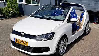 Der VW Polo GTI Beach Edition steht vor einer Halle, statisch von vorne links fotografiert. - Foto: Custom Dreams