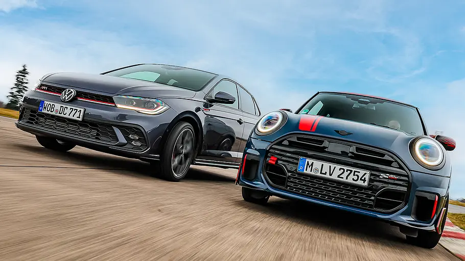 Blick von schräg vorne auf den fahrenden VW Polo GTI und Mini Cooper JCW.