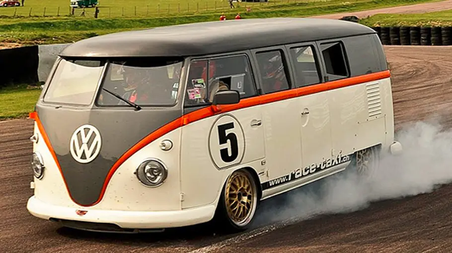 Das VW T1 Race Taxi fahrend von schräg vorne.