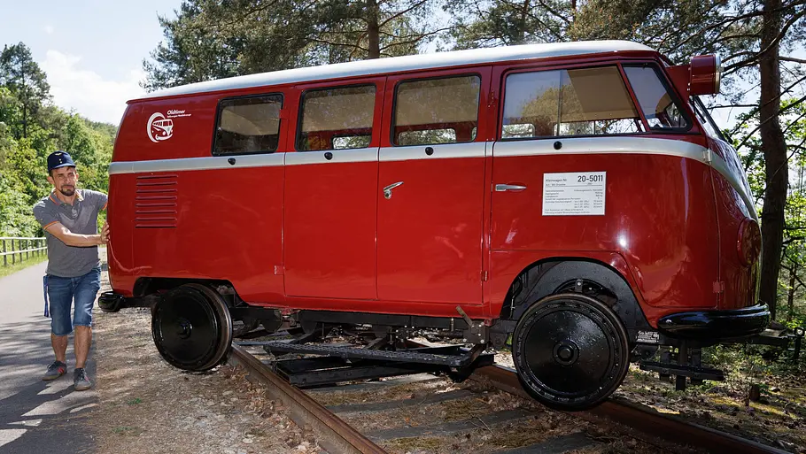 VW T1 Draisine (1954) mit Hydraulik-Hebeeinrichtung schwebt über den Gleisen und ist gerade dabei, sich im Stand zu drehen.