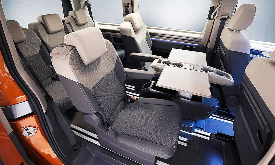 VW Multivan (2021) Die Einzelsitze in der zweiten Sitzreihe des VW Multivan (2021) mit dazwischen ausgeklapptem Tisch.