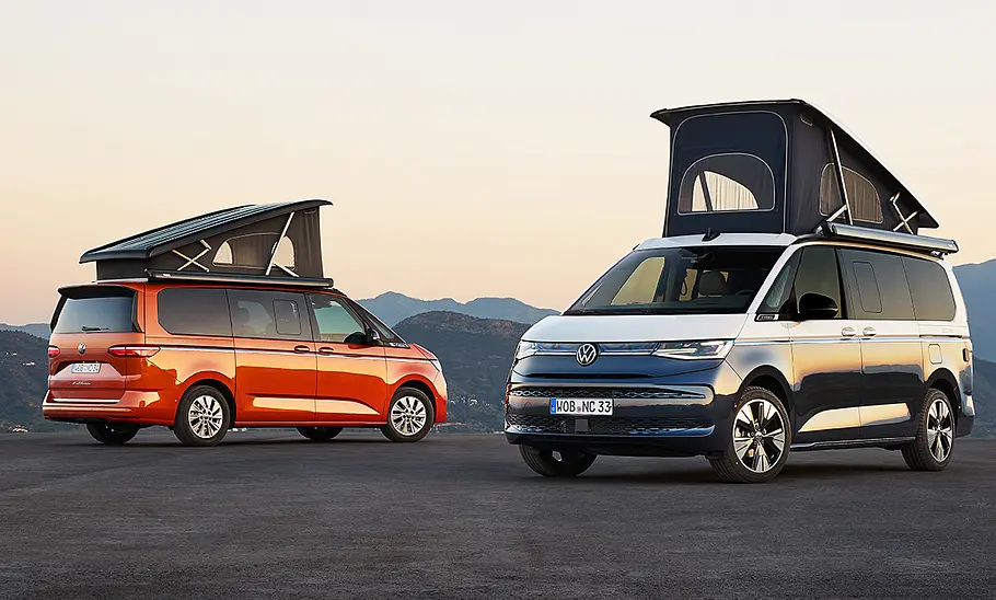 VW California (2024) Das Bild zeigt zwei Versionen des VW California (2024). Beide stehen schräg zur Kamera mit geöffnetem Aufstelldach.