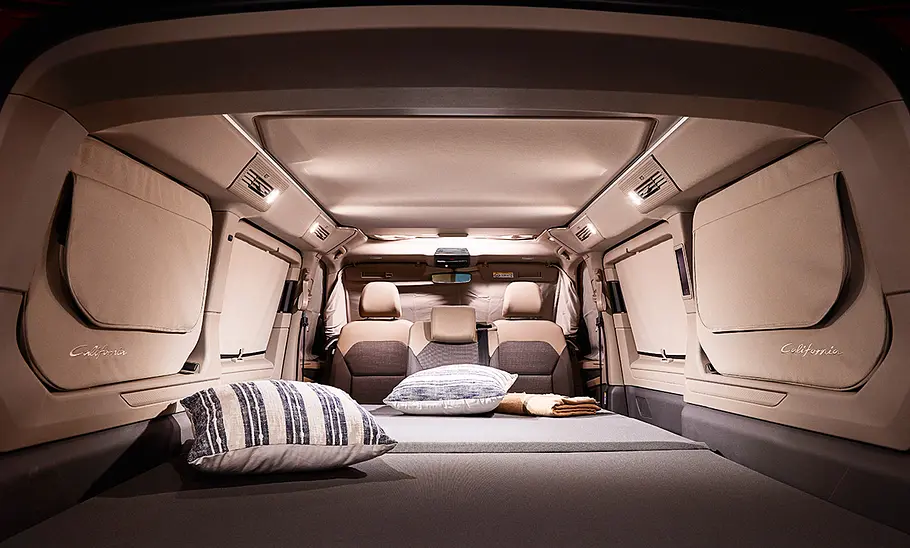 VW California (2024) Das Foto zeigt den zum Bett umgebauten Wohnraum des VW California (2024).