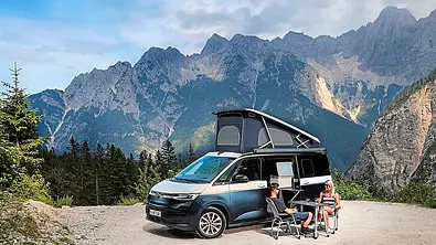 Camping-Reise durch Slowenien im VW T7 California; stehend, Ansicht schräg vorne, Campingmöbel sind aufgebaut, Alpenpanorama - Foto: VW Nutzfahrzeuge (Uli Sonntag)