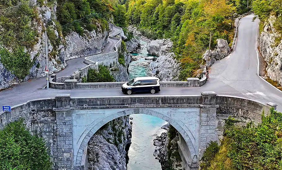 Camping-Reise durch Slowenien im VW T7 California Camping-Reise durch Slowenien im VW T7 California; stehend auf einer Brücke über die Soča, Ansicht von seitlich oben