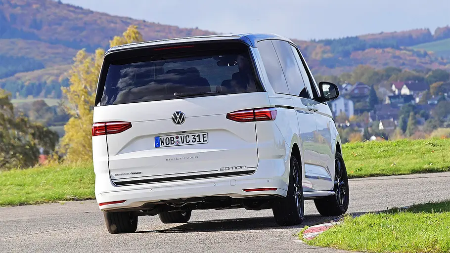Blick von schräg hinten auf den fahrenden VW T7 Multivan.