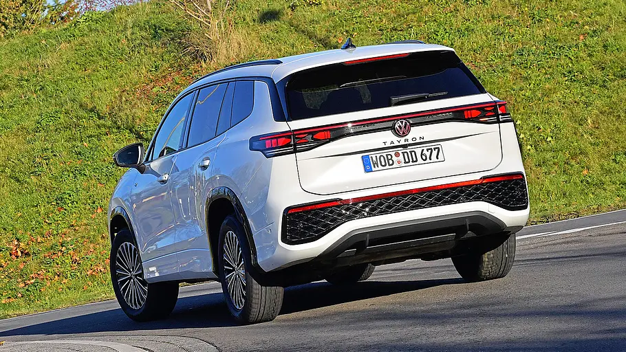 Blick von schräg hintenauf den fahrenden VW Tayron.