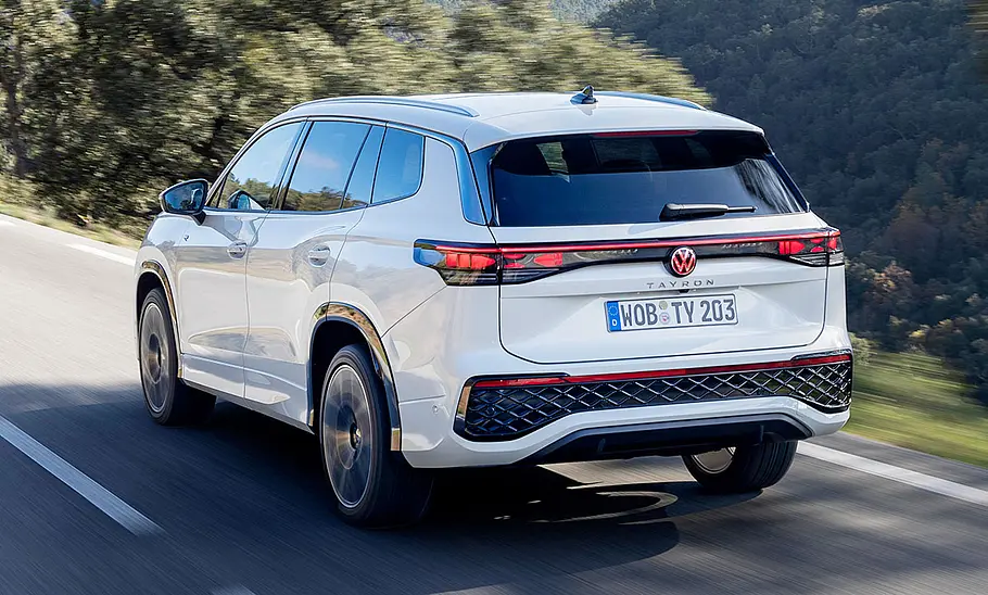 Der VW Tayron (2025) fahrend von schräg hinten fotografiert.
