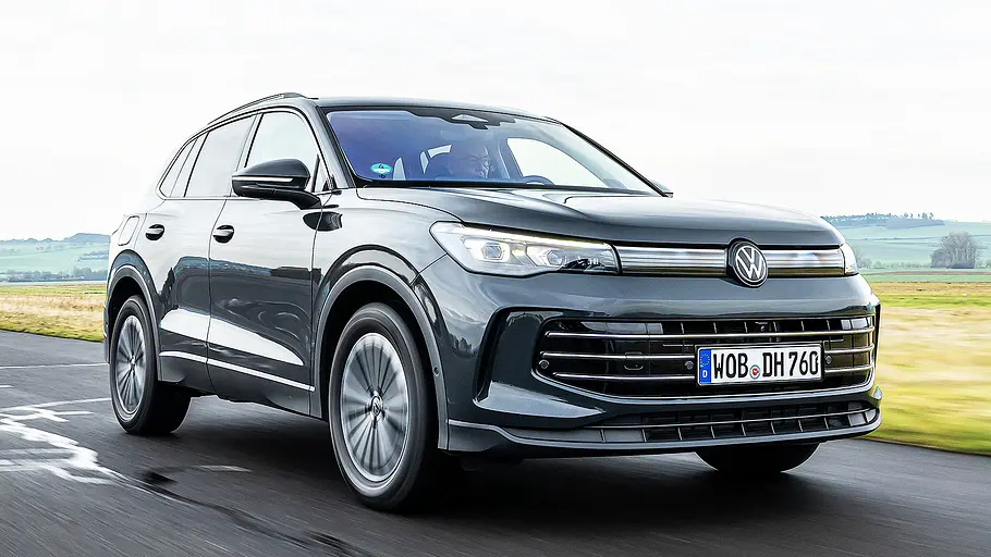 Blick von schräg vorne auf den fahrenden VW Tiguan.