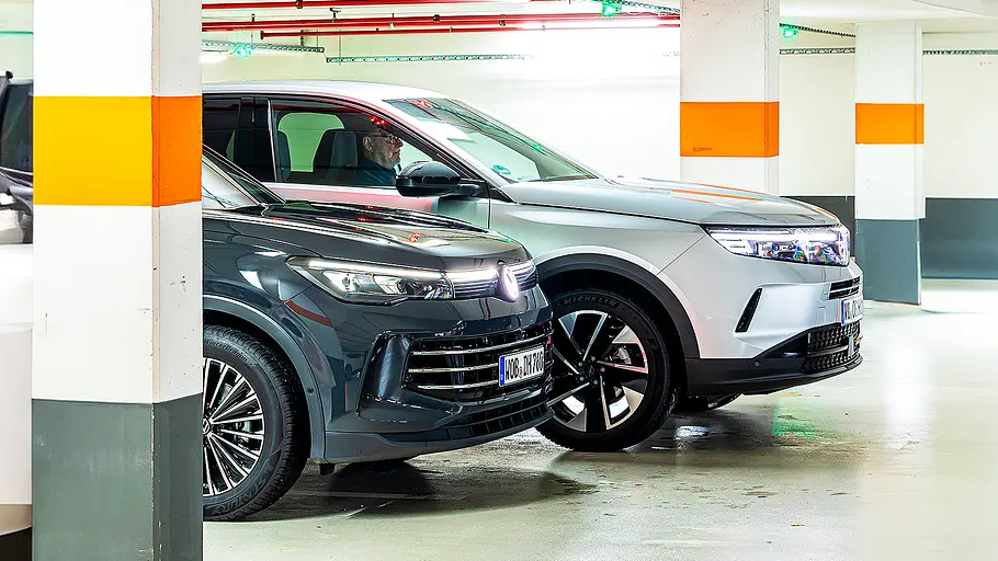 Blick von der Seite auf die beiden SUV VW Tiguan und Opel Grandland, die in einer Tiefgarage zwischen den Tragesäulen parken.