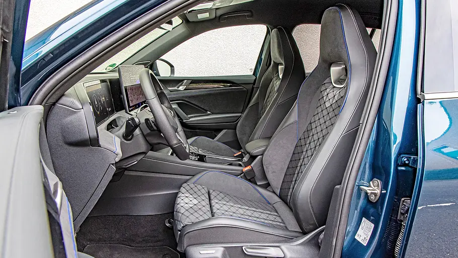 Toyota RAV4 und VW Tiguan im Vergleich Die offene Fahrertür des VW Tiguan gibt den Blick auf schwarze Sportsitze mit blauen Nähten, Lenkrad und zwei Displays im Cockpit frei.