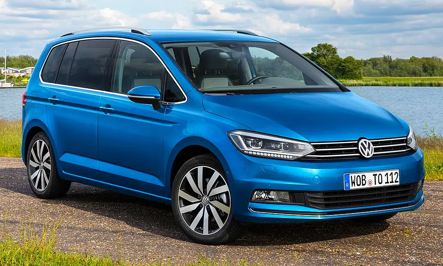 VW Touran (2015) Der VW Touran (2015) steht an einem Gewässer, von vorne rechts fotografiert.