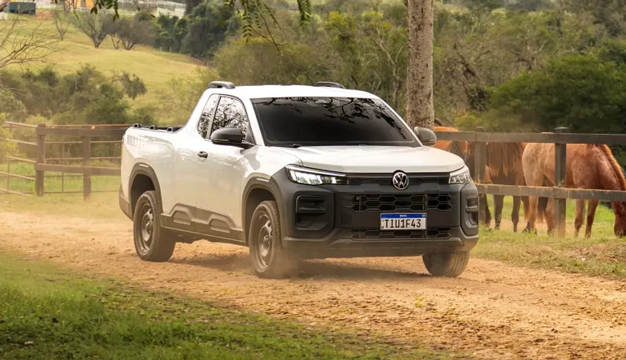 VW Tukan Der VW Tukan an einer Pferdekoppel vorbeifahrend von schräg vorne rechts.