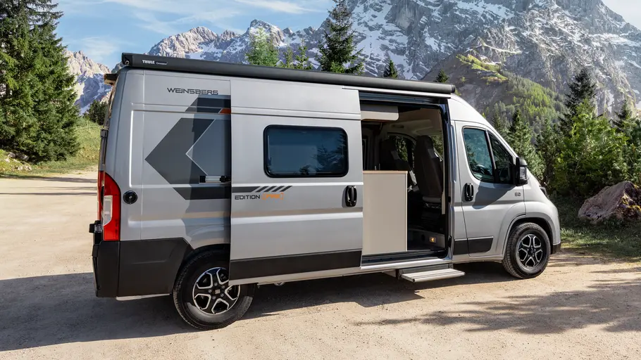 Weinsberg Carabus Grey Edition (Fire) 600 ME Die Außenaufnahme zeigt den Weinsberg Carabus Grey Edition (Fire) 600 ME von der Seite bei geöffneter Schiebetür.