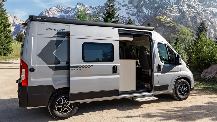 Weinsberg Carabus Grey Edition (Fire) 600 ME Die Außenaufnahme zeigt den Weinsberg Carabus Grey Edition (Fire) 600 ME von der Seite bei geöffneter Schiebetür.
