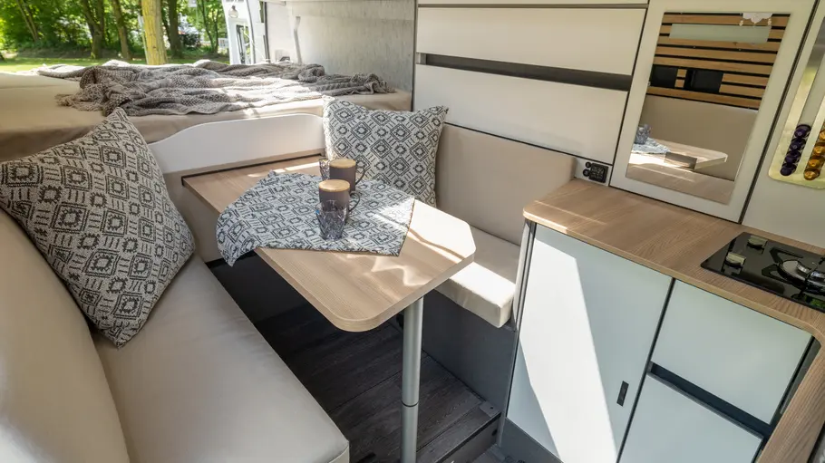 Die Innenansicht zeigt die Sitzgruppe am Fußende des Bett im Weinsberg Caralife 630 LQ.
