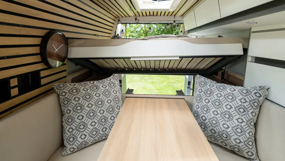 Der Lattenrost des Heckbetts im Weinsberg Caralife 630 LQ im Bereich der Sitzgruppe nach oben geklappt, um die Heckgarage aus dem Wohnraum zugänglich zu machen.