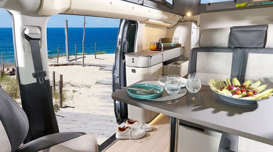 Westfalia Jules Verne Die Innenaufnahme zeigt den Wohnraum des Westfalia Jules Verne bei geöffneter Seitentür.