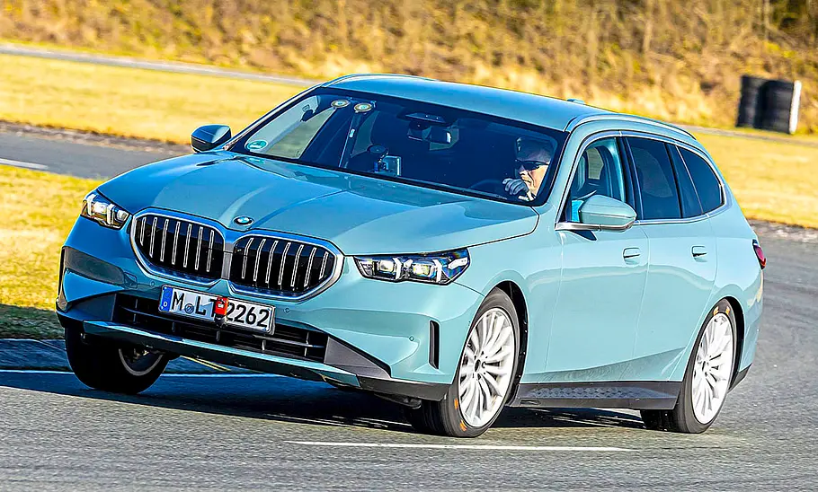 Der BMW 520d fahrend von schräg vorne fotografiert.
