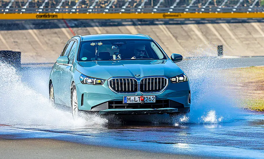 Der BMW 520d fahrend von schräg vorne fotografiert.