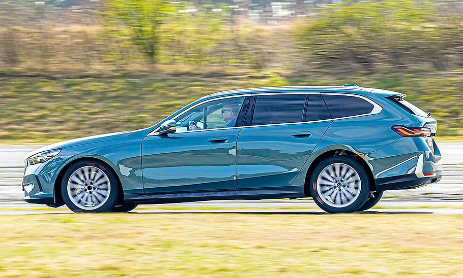 Der BMW 520d fahrend von der Seite fotografiert.