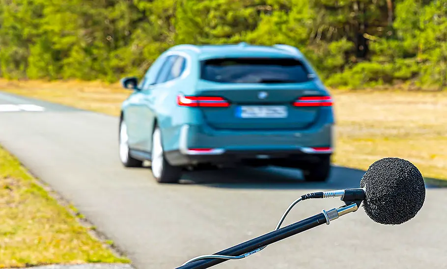 Der BMW 520d fahrend von schräg hinten fotografiert.